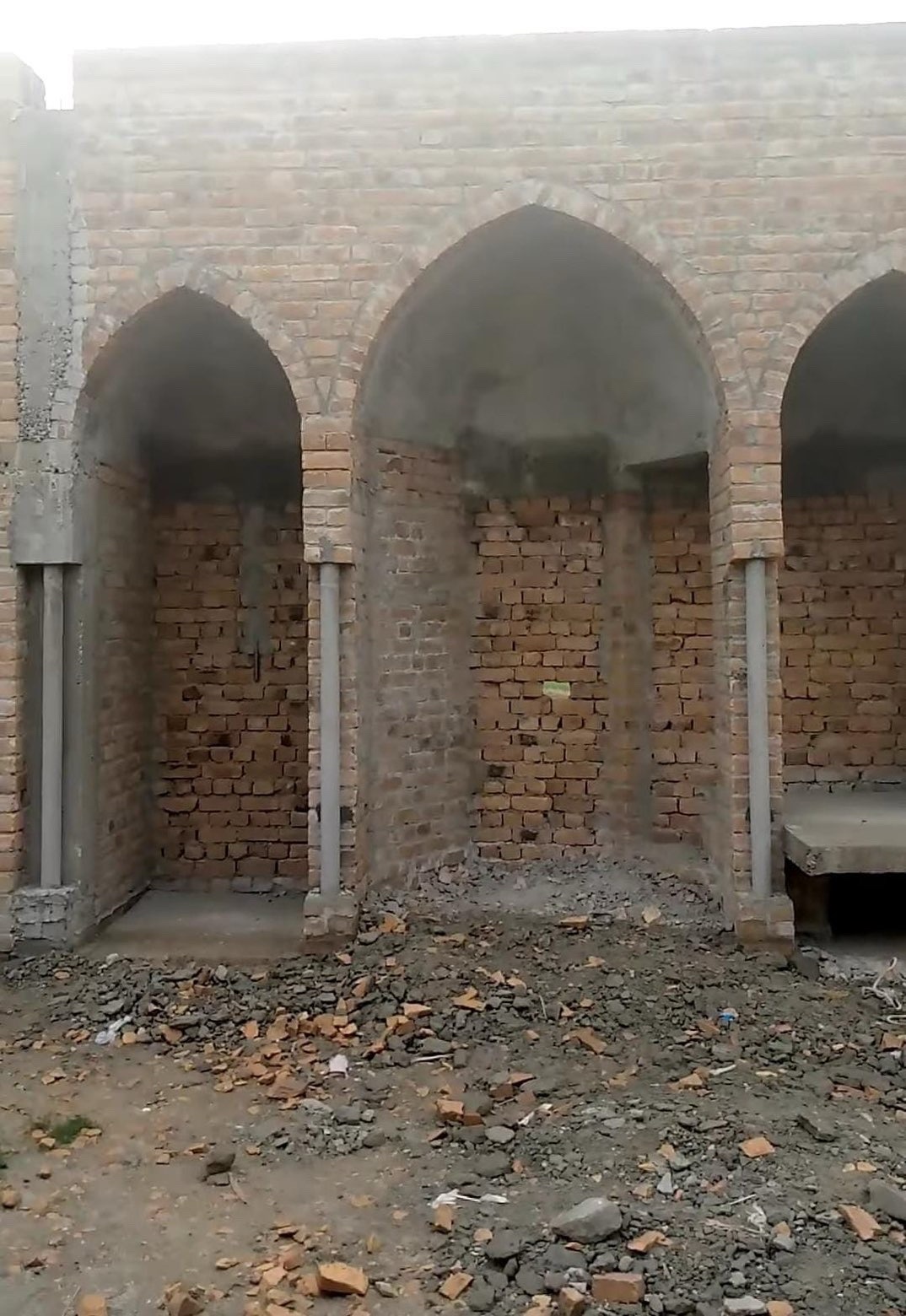 Three completed brick archways inside the mosque under construction